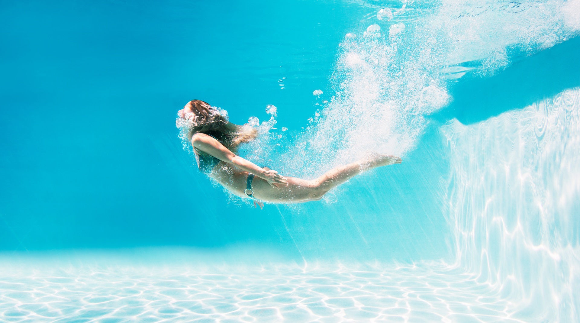 Frau taucht elegant im Wasser | Pools kaufen